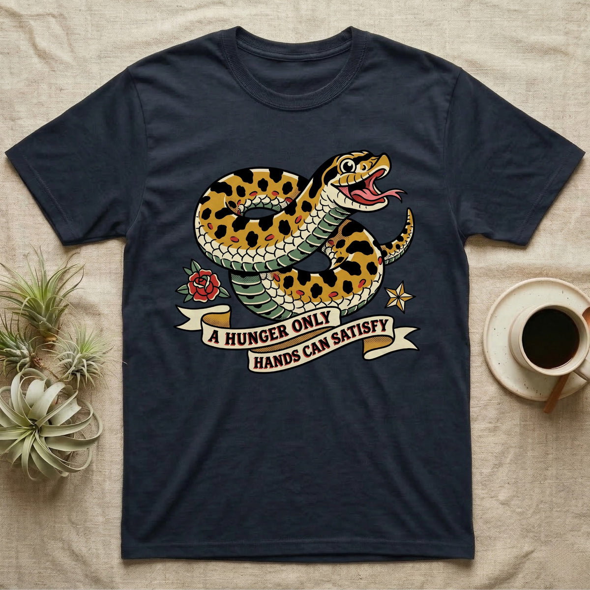 Hognose Hunger Flash T-Shirt in Navy — American-traditional tattoo-flash illustration of a hognose snake in a heroic coil with a banner reading the feeding-hunger line.