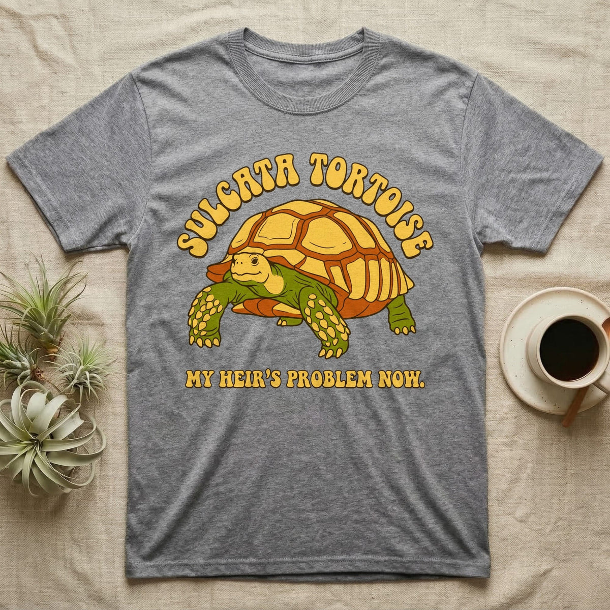 Gray t-shirt with Sulcata tortoise graphic and text "MY HEIR'S PROBLEM NOW."
