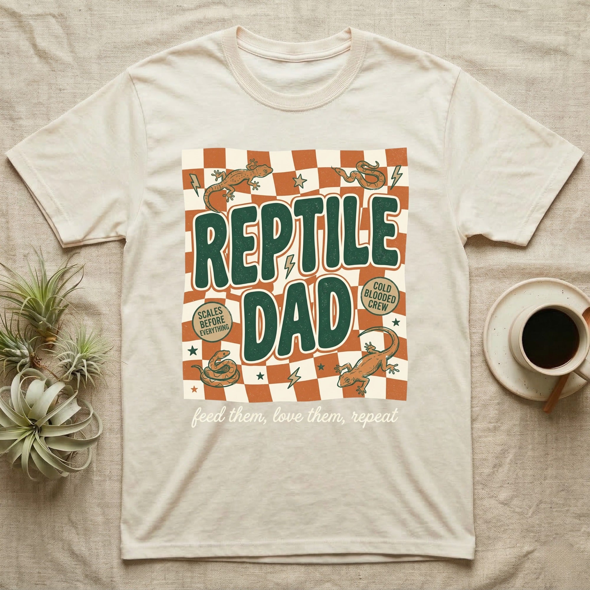 Cream t-shirt with "Reptile Dad" and checkered pattern, featuring lizards.