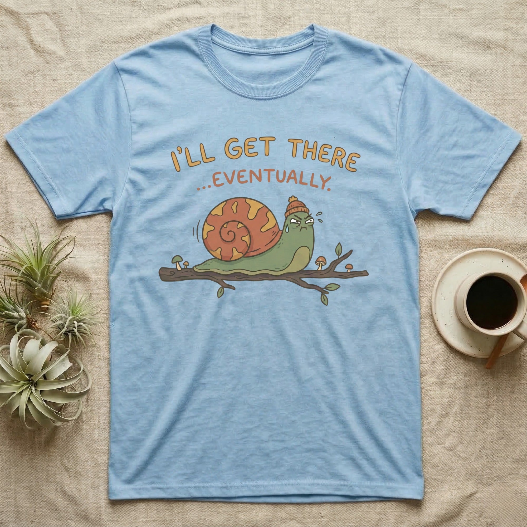 Light blue t-shirt with a cartoon snail on a branch, saying "I'll get there... eventually."