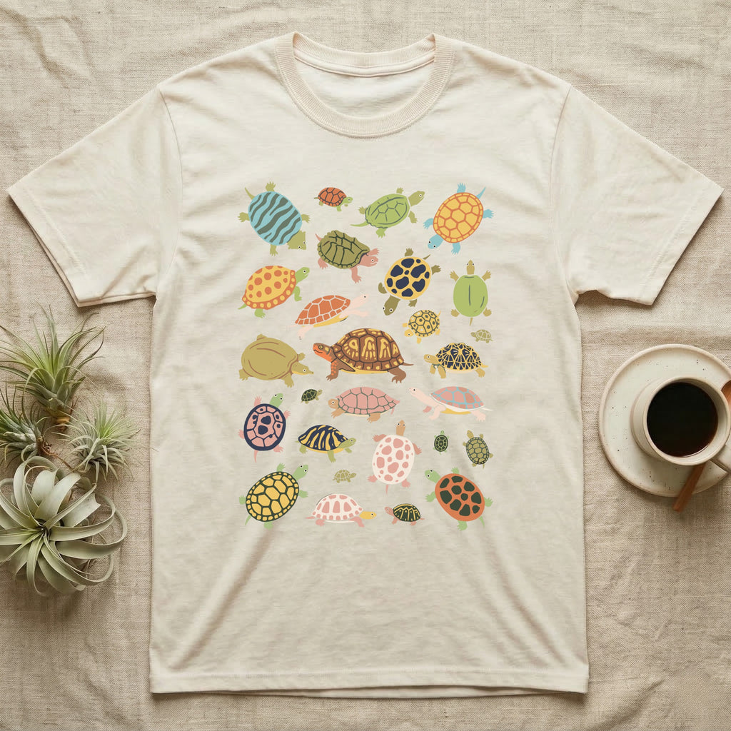 Box Turtle Specimen Plate T-Shirt in Natural — Twenty-five turtles and tortoises painted flat in chalky colour, scattered across grey, each facing a different way.
