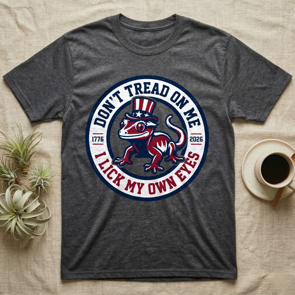 Crested Gecko 1776 T-Shirt in Dark Heather — Distressed crest of a crested gecko in a top hat with text Don't Tread On Me and I Lick My Own Eyes.