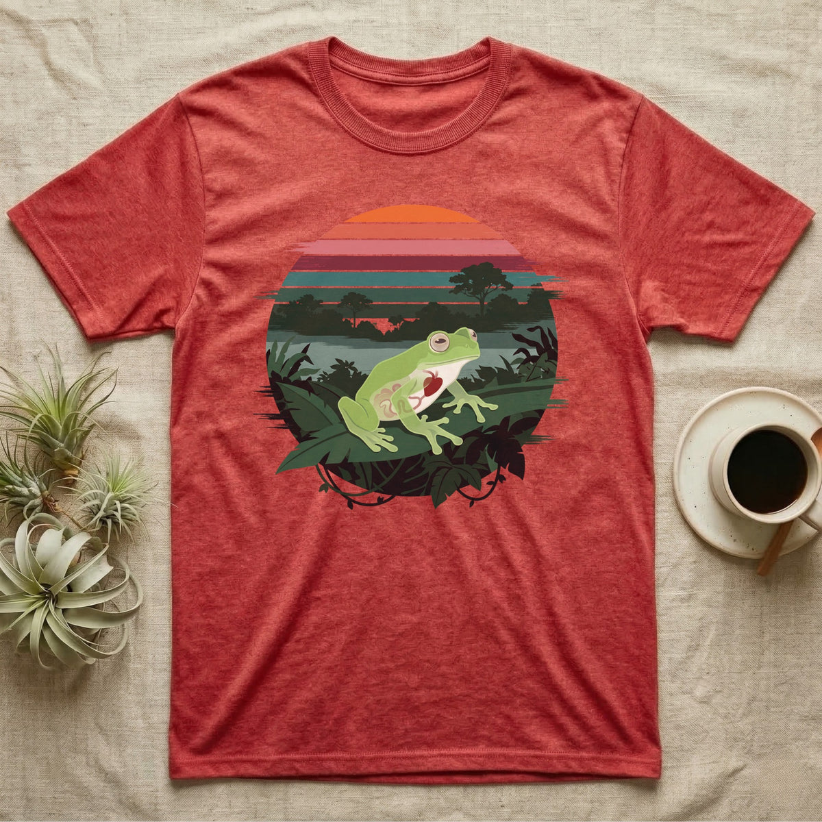 Glass Frog See-Through T-Shirt in Heather Red — Flat-colour circle-window illustration of a glass frog silhouetted crossing a rainforest canopy scene.
