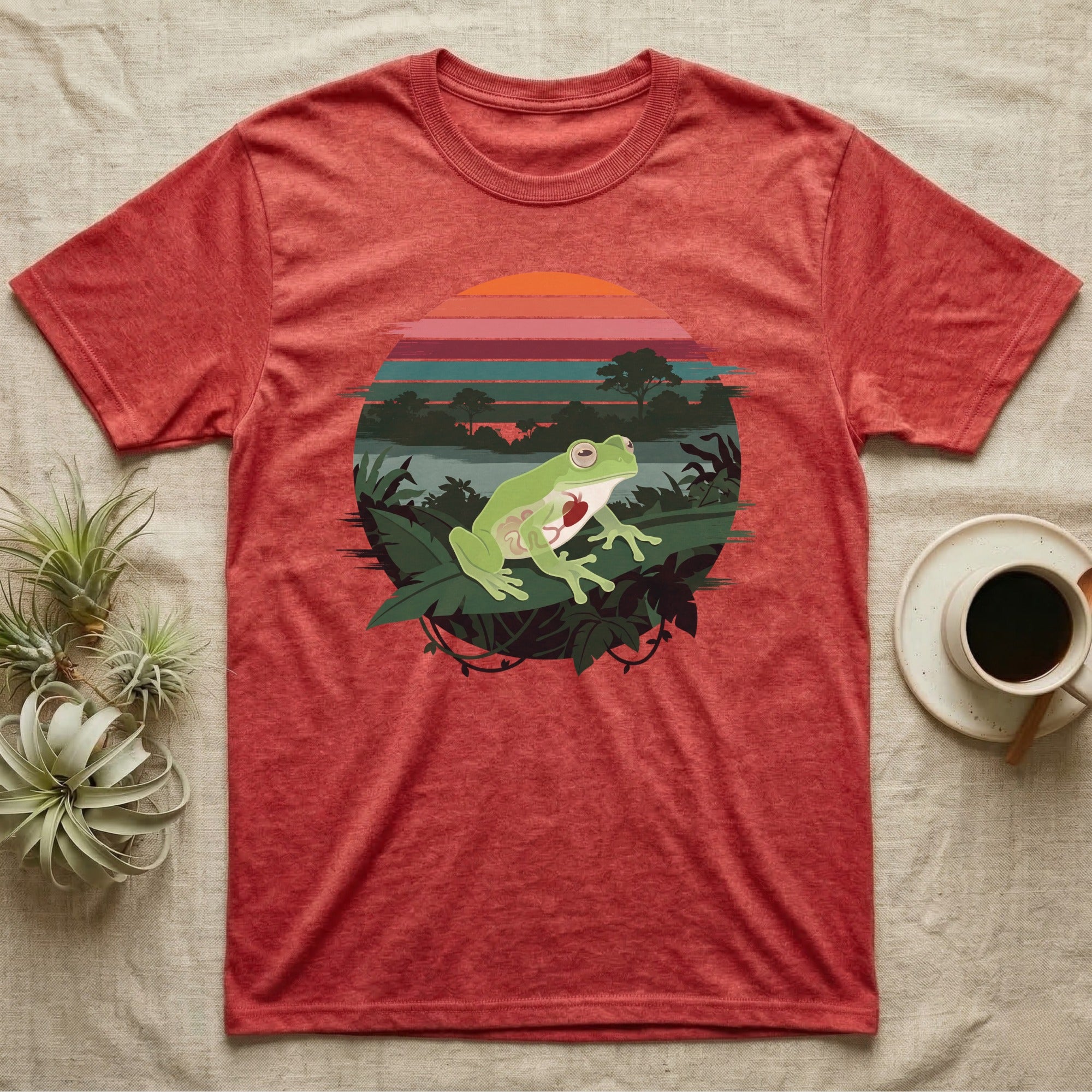 Glass Frog See-Through T-Shirt in Heather Red — Flat-colour circle-window illustration of a glass frog silhouetted crossing a rainforest canopy scene.