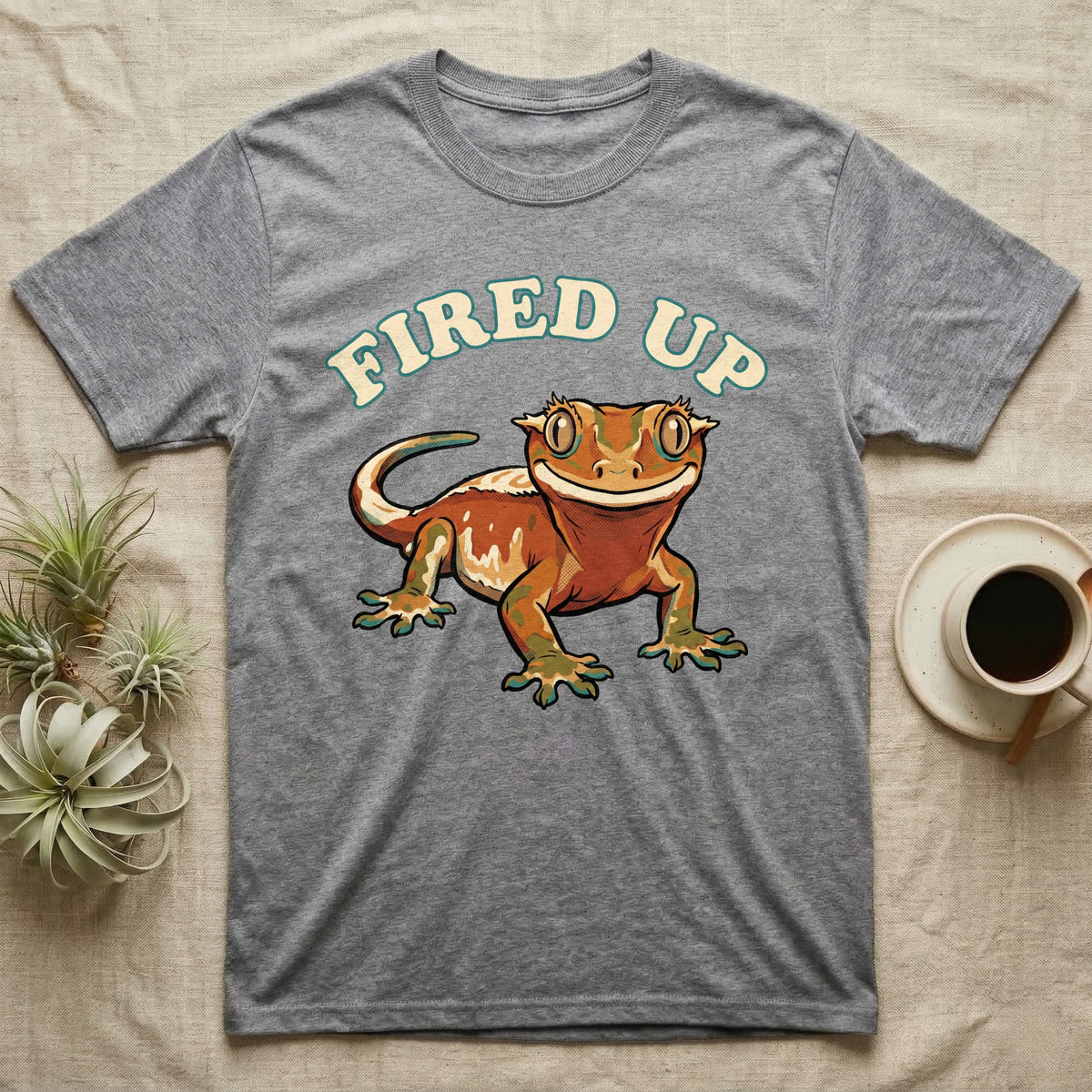 Fired Up Crested Gecko T-Shirt in Sport Grey — Retro 90s-style illustration of a fired-up crested gecko under a bold arc headline reading Fired Up.