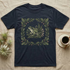 Dark blue t-shirt with frog and mushroom botanical illustration in floral frame.