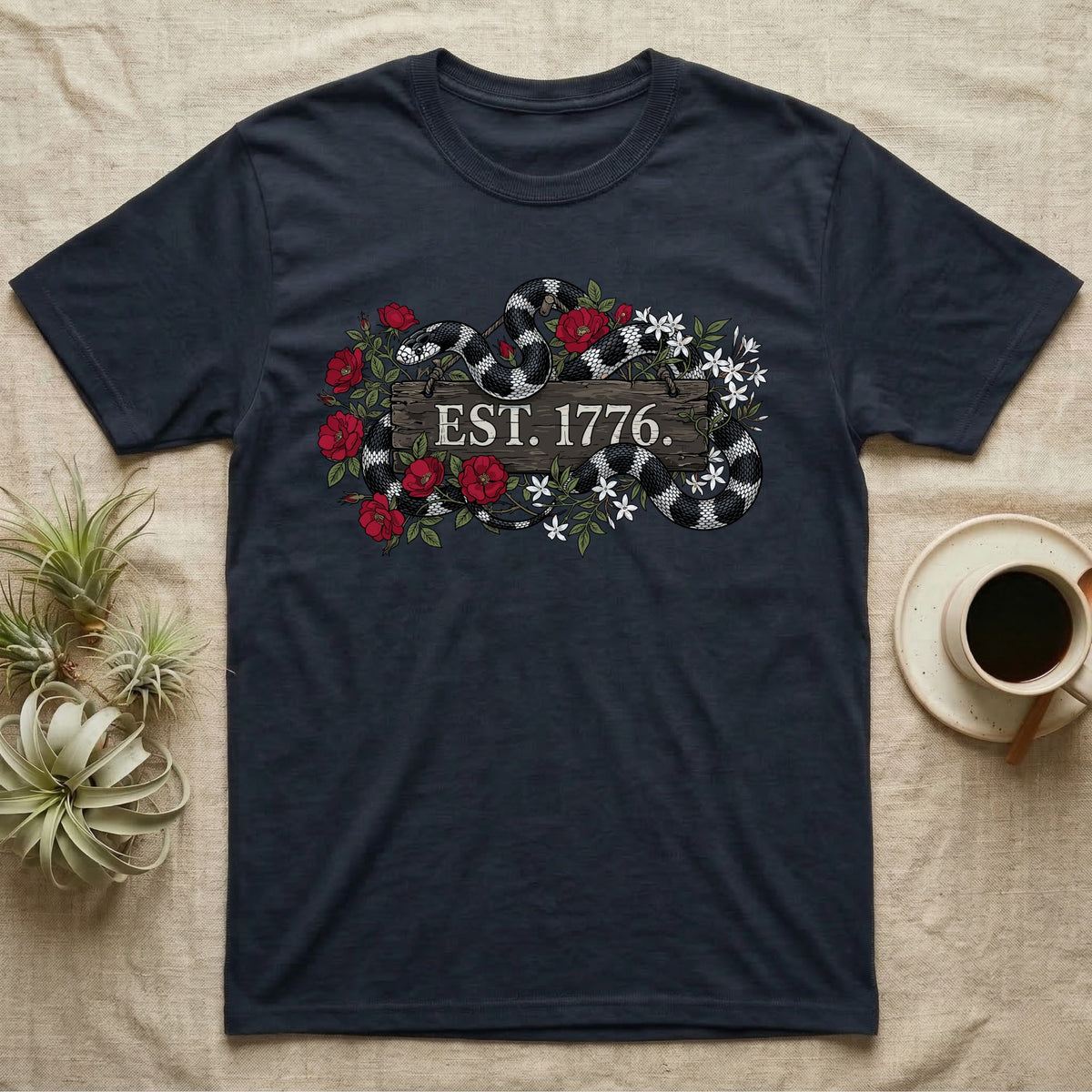 Kingsnake Floral 1776 T-Shirt in Navy — Black-and-white California kingsnake woven through roses and jasmine around a wooden sign reading Est. 1776.