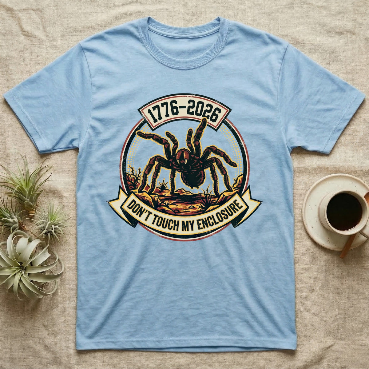 Tarantula Don't Touch Enclosure Tee in Light Blue — Distressed circular badge of a defensive tarantula on desert ground, red and gold banner reading Don't Touch My Enclosure, on black.
