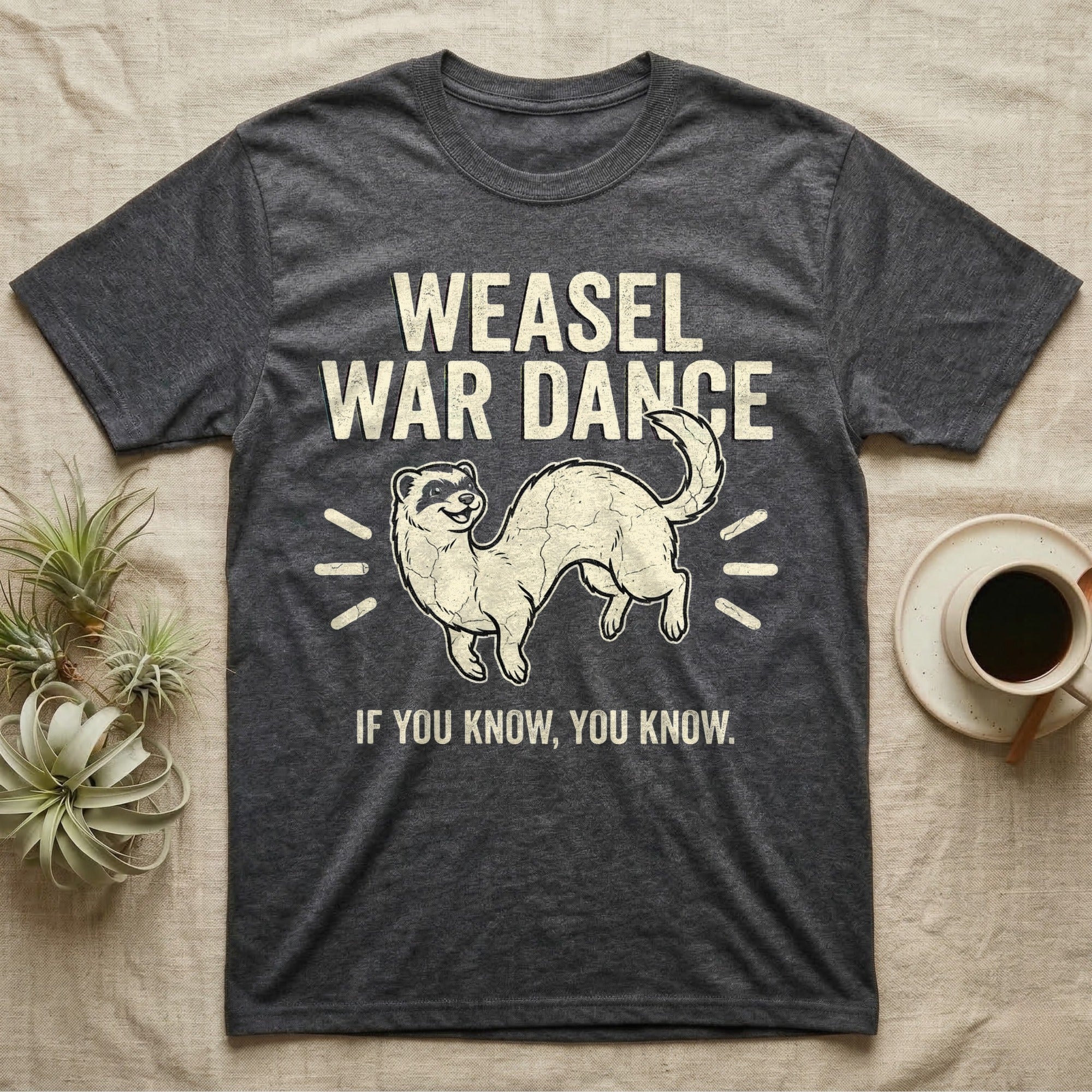 Weasel War Dance Ferret Tee in Dark Heather — Grunge-distressed ferret mid-war-dance in S-curve bounce with stacked type "Weasel War Dance / If You Know."