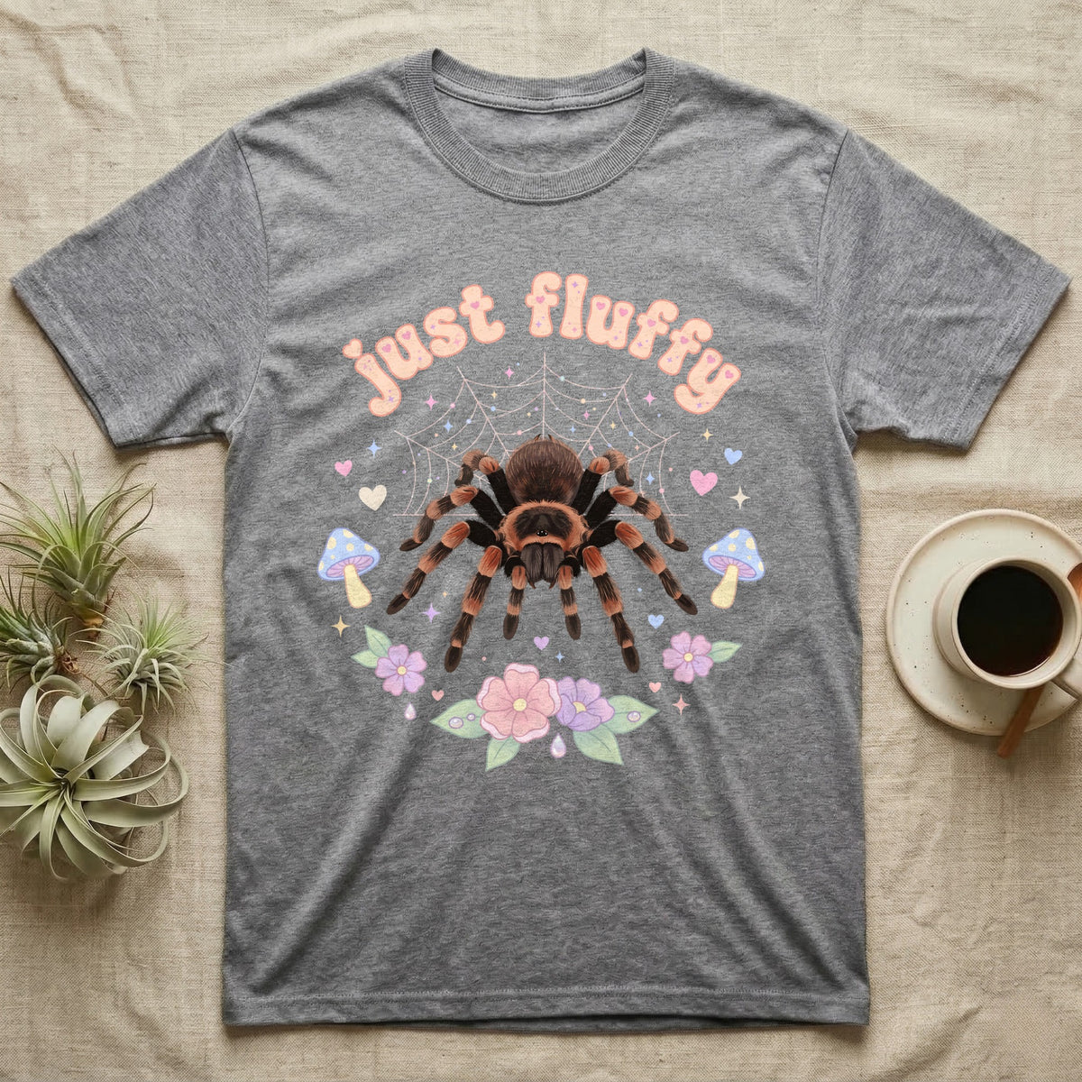 Mexican Redknee Tarantula Baby T-Shirt in Sport Grey — Fuzzy Mexican redknee tarantula on a pastel web with blossoms under puffy peach bubble text "just fluffy".