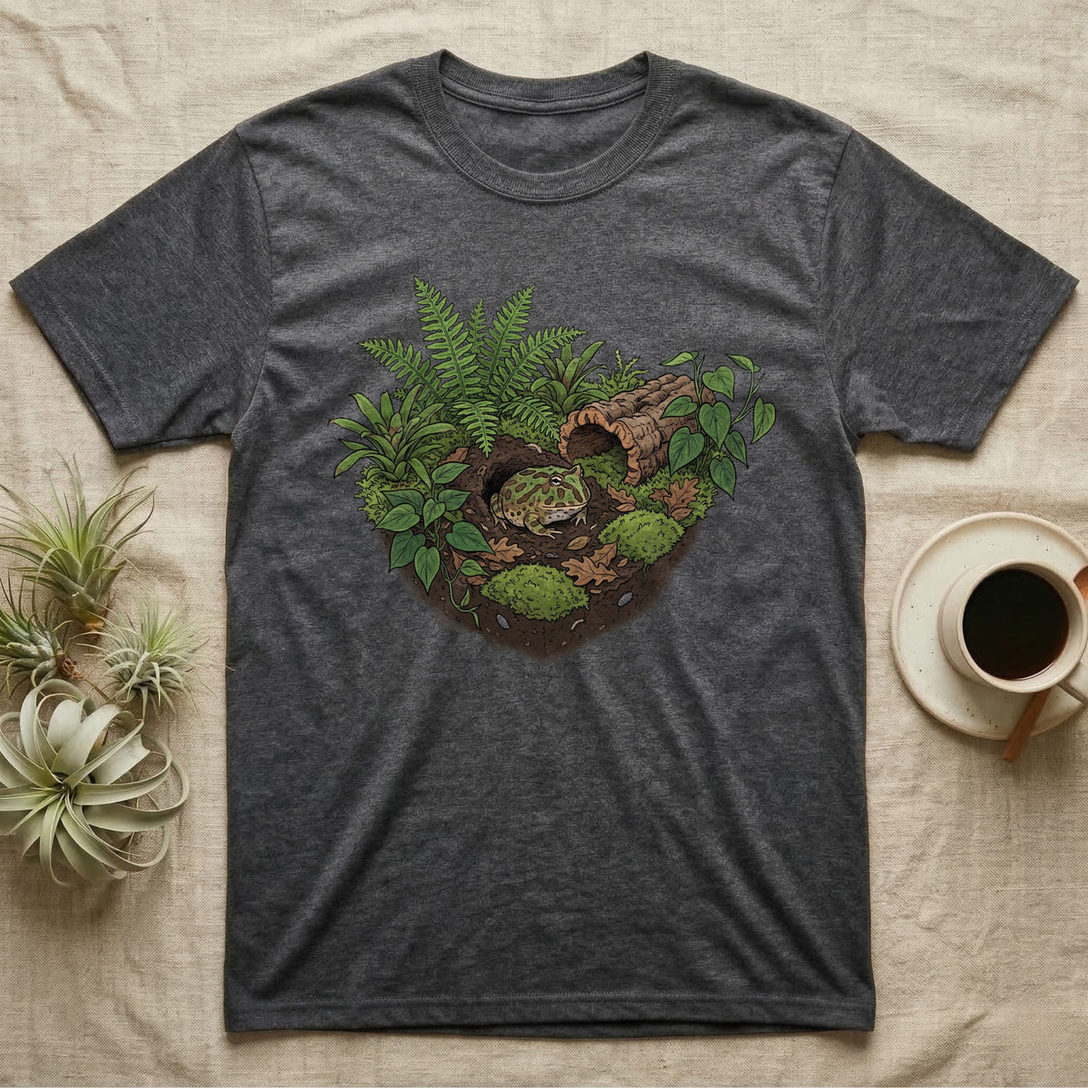 Pacman Frog Vivarium T-Shirt in Dark Heather — Botanical illustration of a pacman frog thriving in a planted bioactive vivarium beside a small empty plastic cup.