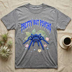 Cobalt Blue Tarantula Feral T-Shirt in Sport Grey — Cobalt blue tarantula with electric-blue legs under jagged cobalt metal text PRETTY BUT PSYCHO with pastel blossoms