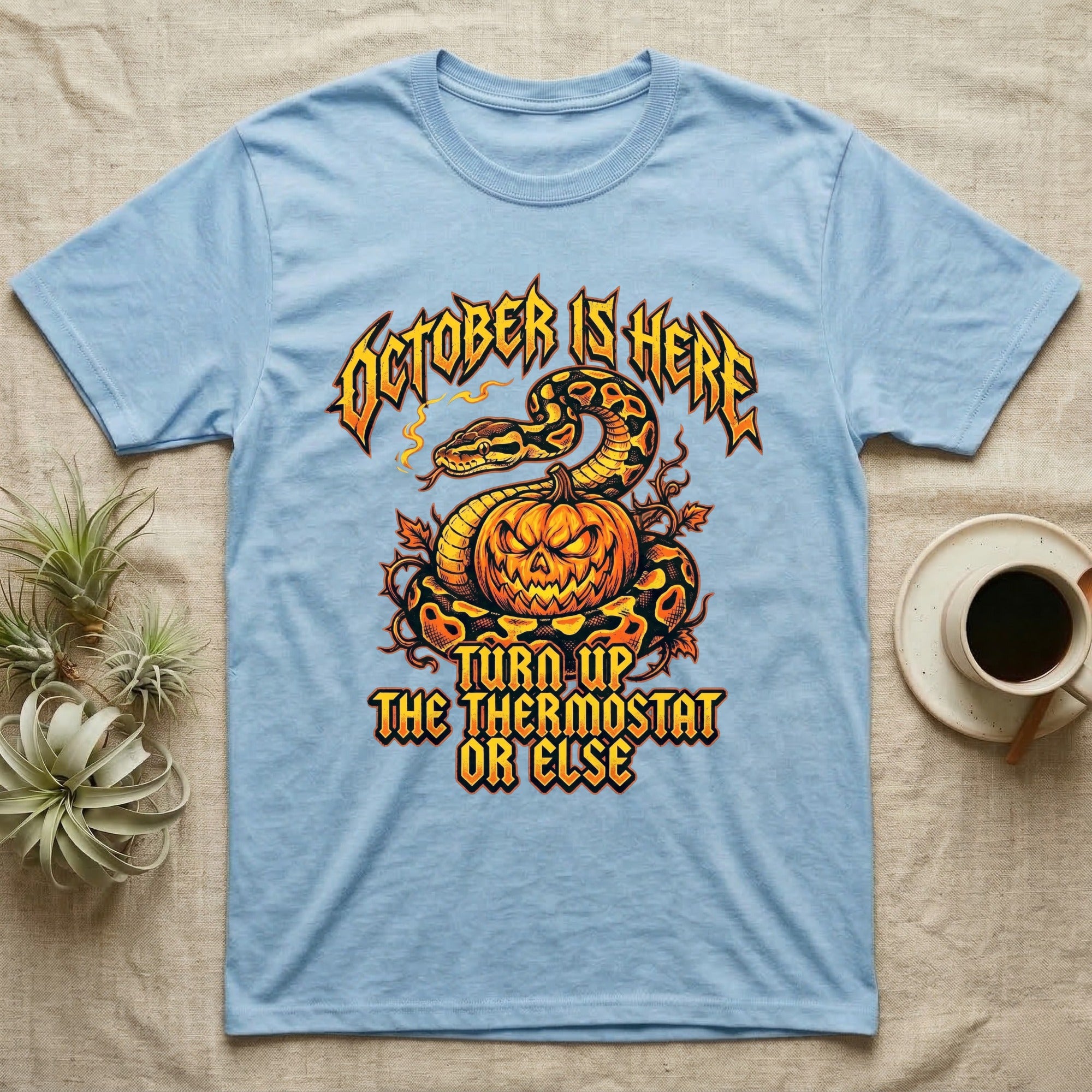Ball Python October Thermostat T-Shirt in Light Blue — Metal-band style ball python coiled over a glowing jack-o'-lantern, "October Is Here, Turn Up the Thermostat Or Else."