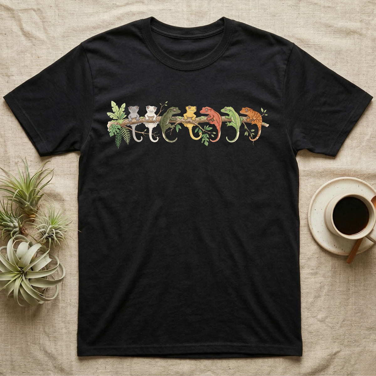 Crested Gecko Canopy Crew T-Shirt in Black — Watercolor illustration of seven crested gecko colour morphs perched on a branch, dark grey T-shirt design.