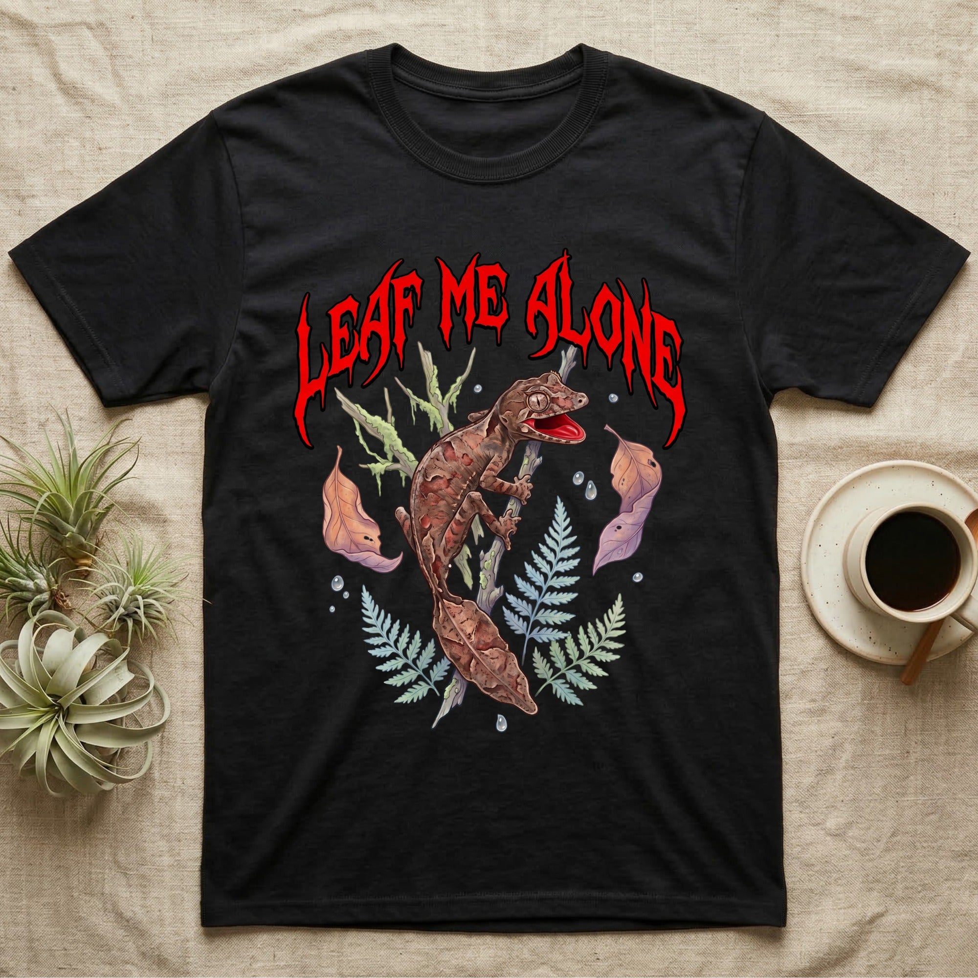 Satanic Leaf-Tailed Gecko Feral T-Shirt in Black — Satanic leaf-tailed gecko gaping on a twig with dripping blood-red metal "Leaf Me Alone" wordmark above