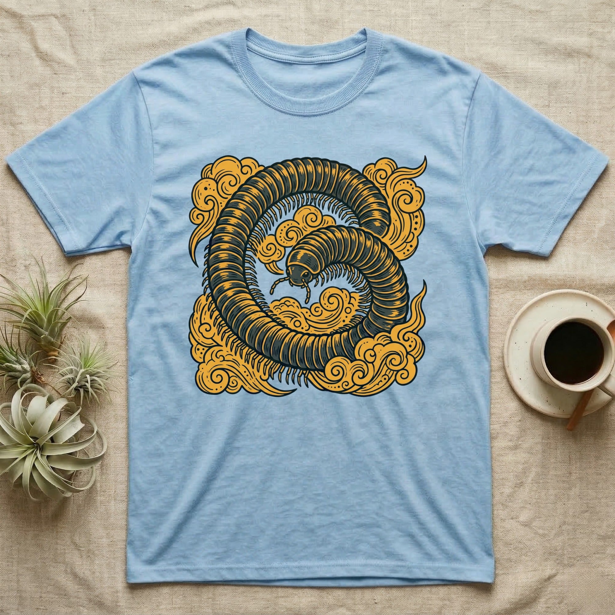 Light blue t-shirt with a stylized dark insect and clouds design.