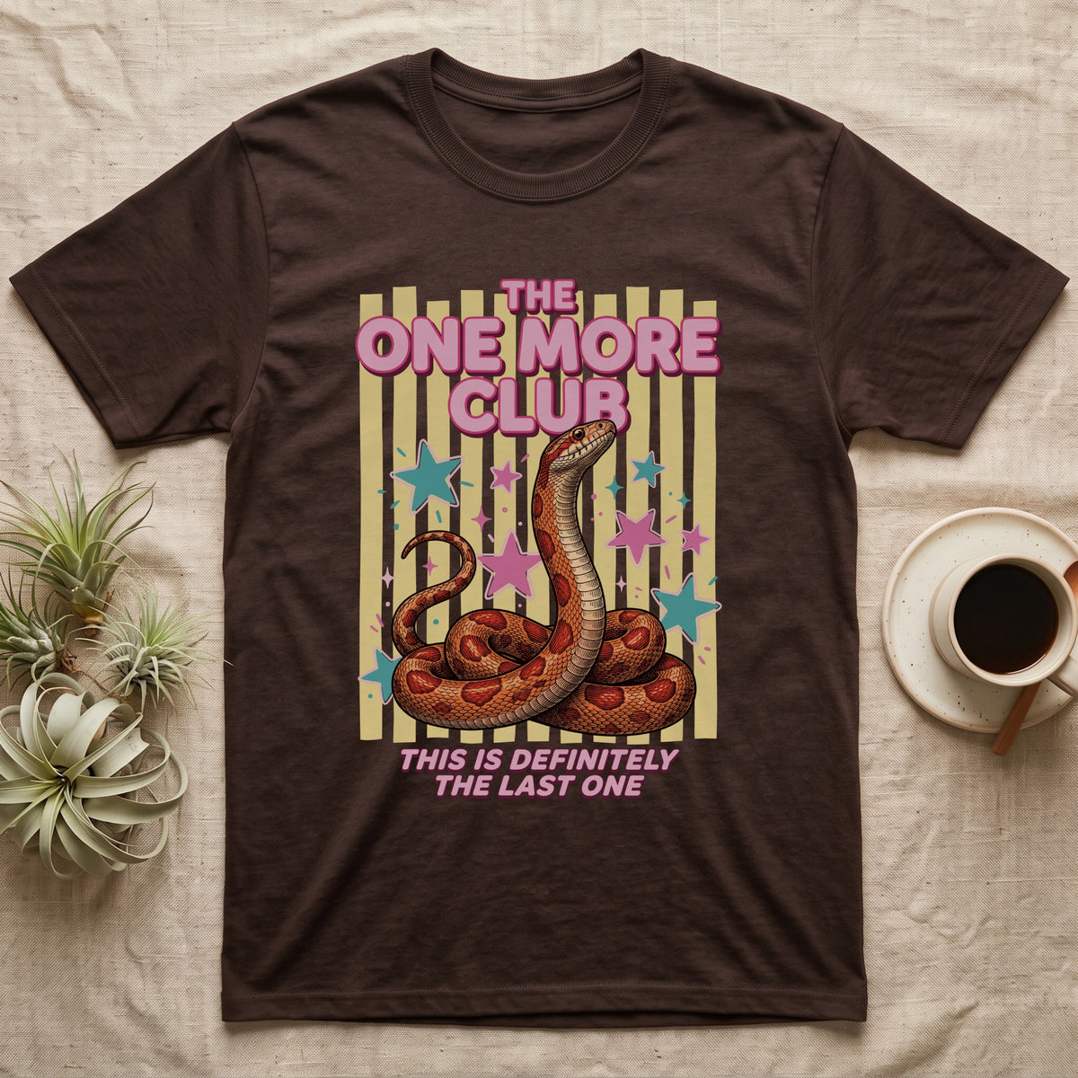 Corn Snake Club T-Shirt in Dark Chocolate — Engraved corn snake sitting deadpan under pink lettering The One More Club, with This is definitely the last one below, on yellow stripes