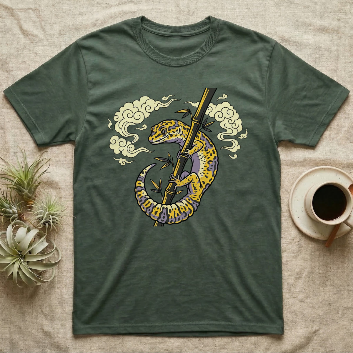 Green t-shirt with a yellow and purple gecko climbing a bamboo stalk.