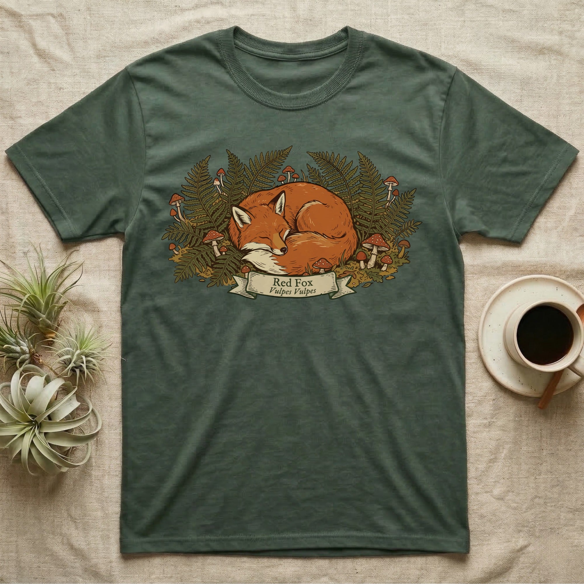 T-shirt with a sleeping red fox surrounded by ferns and mushrooms.