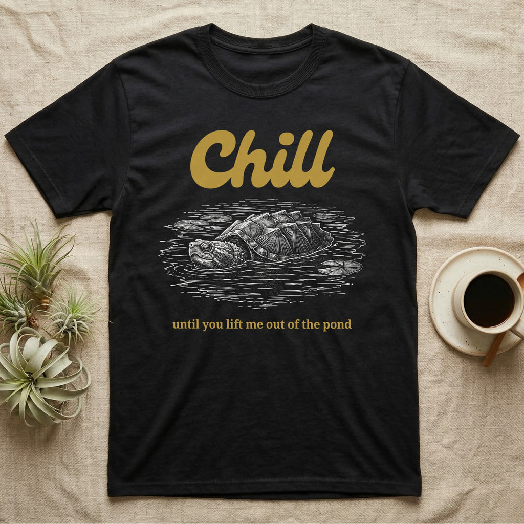 Snapping Turtle Chill T-Shirt in Black — White-line engraving of a snapping turtle floating among lily pads under the word Chill