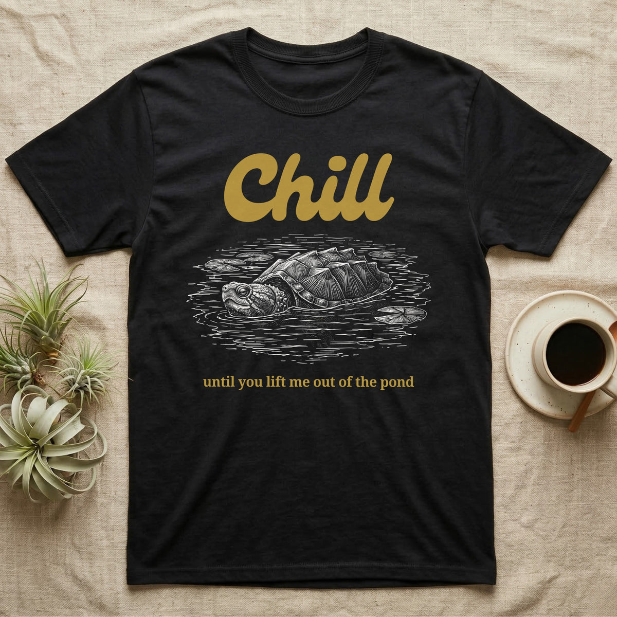 Snapping Turtle Chill T-Shirt in Black — White-line engraving of a snapping turtle floating among lily pads under the word Chill