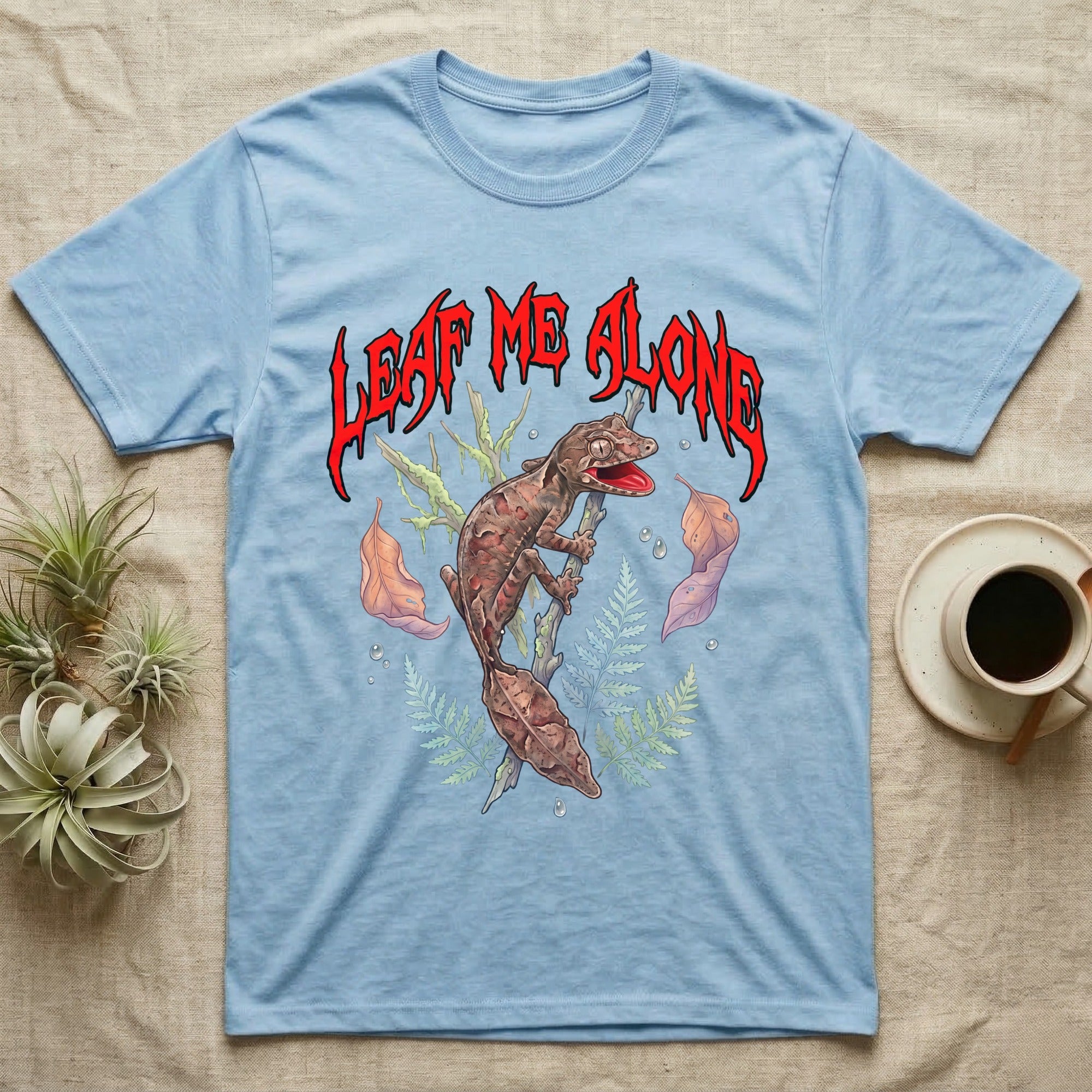 Satanic Leaf-Tailed Gecko Feral T-Shirt in Light Blue — Satanic leaf-tailed gecko gaping on a twig with dripping blood-red metal "Leaf Me Alone" wordmark above