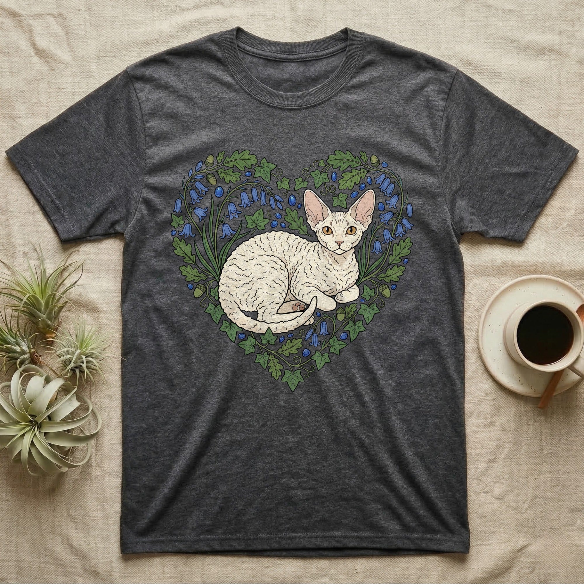 Cornish Rex cat resting inside a heart-shaped floral design on a dark grey t-shirt.