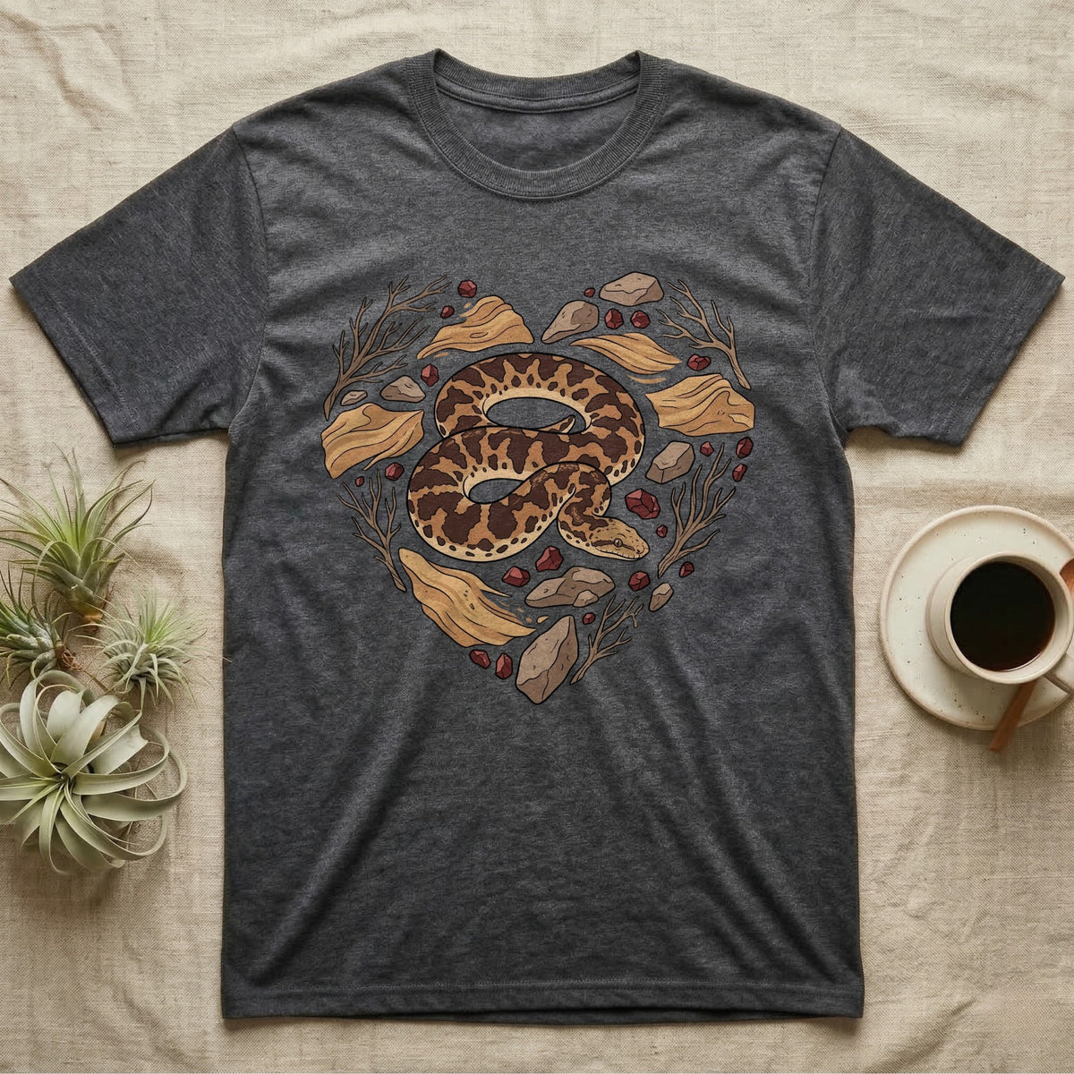 Dark grey t-shirt featuring a heart-shaped design with a snake, stones, and branches.