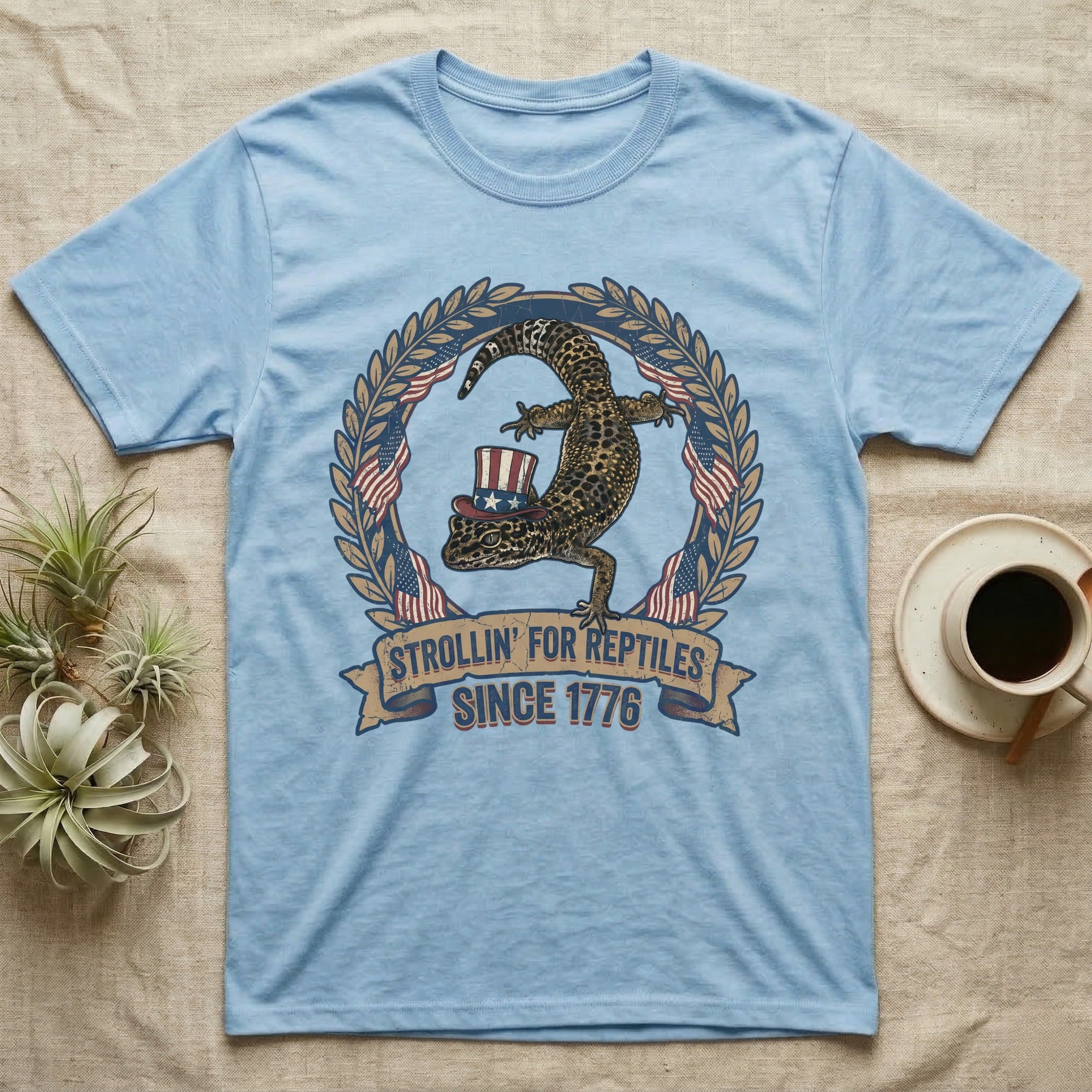 Leopard Gecko 1776 T-Shirt in Light Blue — Vintage badge of a leopard gecko in an Uncle Sam hat with laurel wreath and flags, banner reading Strollin' For Reptiles Since 1776.