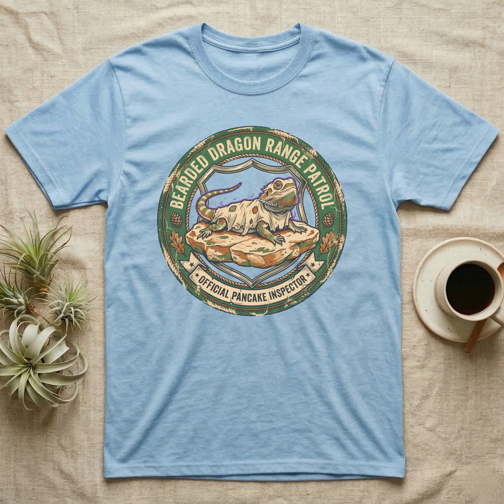 Bearded Dragon Pancake Inspector T-Shirt in Light Blue — Weathered ranger badge of a bearded dragon flattened on a rock, "Bearded Dragon Range Patrol, Official Pancake Inspector."