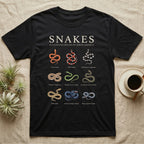 Snake Species Chart T-Shirt in Black — Watercolour chart of nine named North American snakes under a cream serif Snakes title on charcoal grey