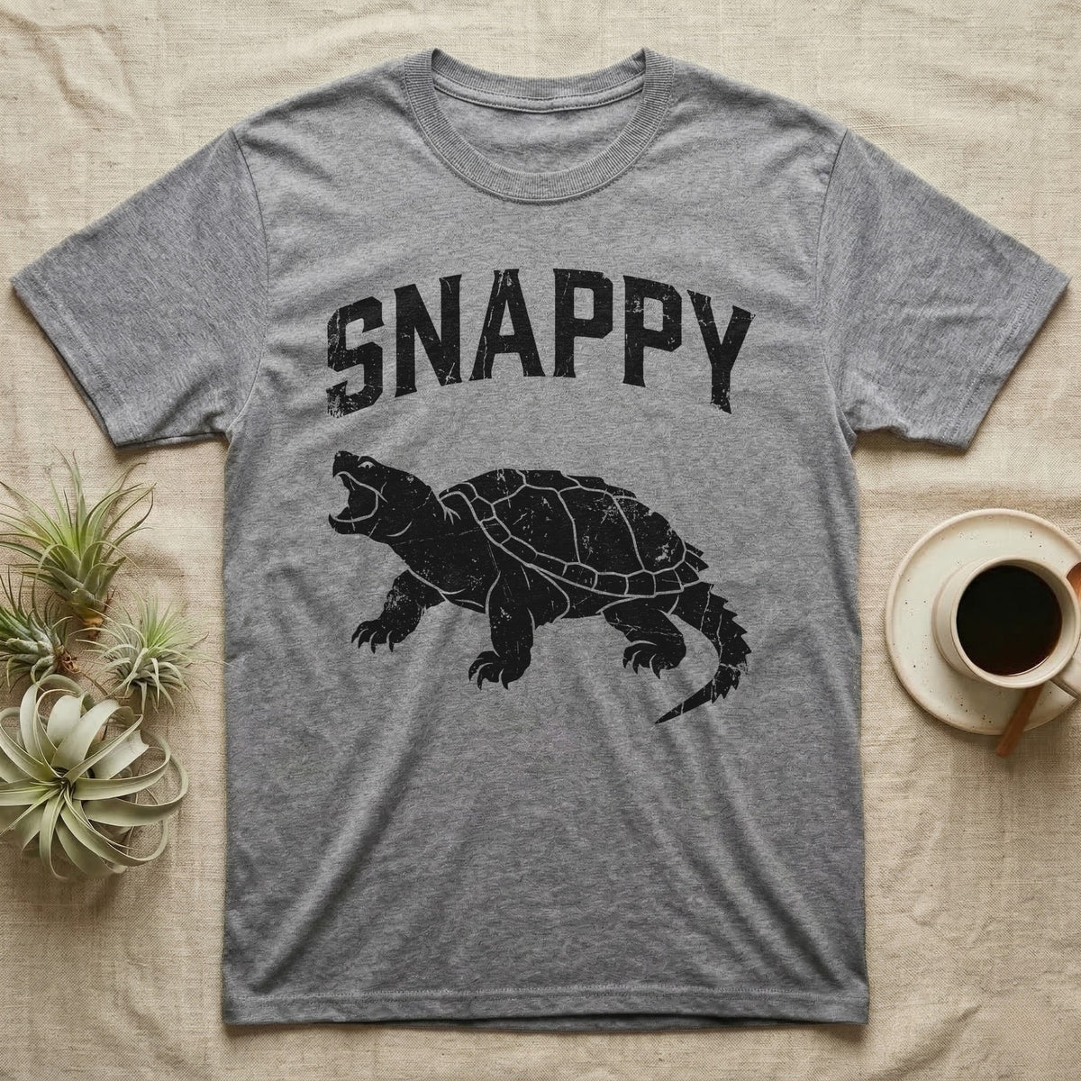 Snapping Turtle Snappy T-Shirt in Sport Grey — Worn one-ink print of a common snapping turtle crouched side-on, jaws open mid-snap, under the arched word SNAPPY