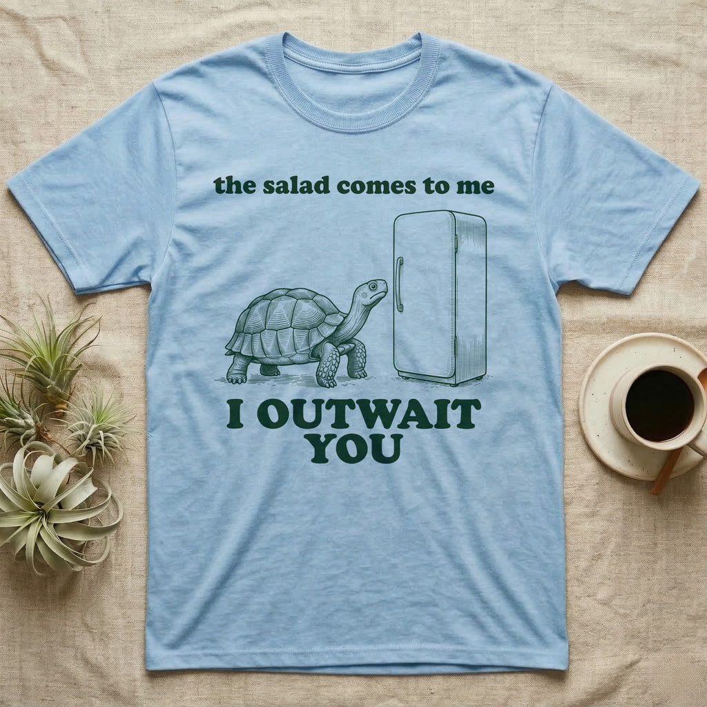 Sulcata Fridge Standoff T-Shirt in Light Blue — Engraved sulcata tortoise waiting in front of a closed fridge between the words the salad comes to me and I OUTWAIT YOU.