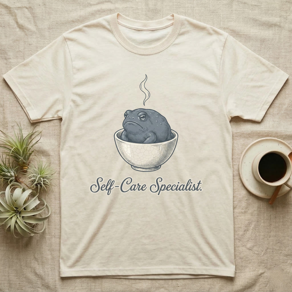Cream t-shirt with a frog in a steaming bowl, reading "Self-Care Specialist."