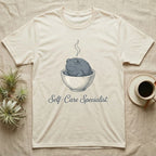 Cream t-shirt with a frog in a steaming bowl, reading "Self-Care Specialist."