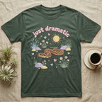 Western Hognose Snake Baby T-Shirt in Military Green — Pastel western hognose snake in a low coil with tongue out among grasses, puffy pink bubble wordmark "just dramatic" above.