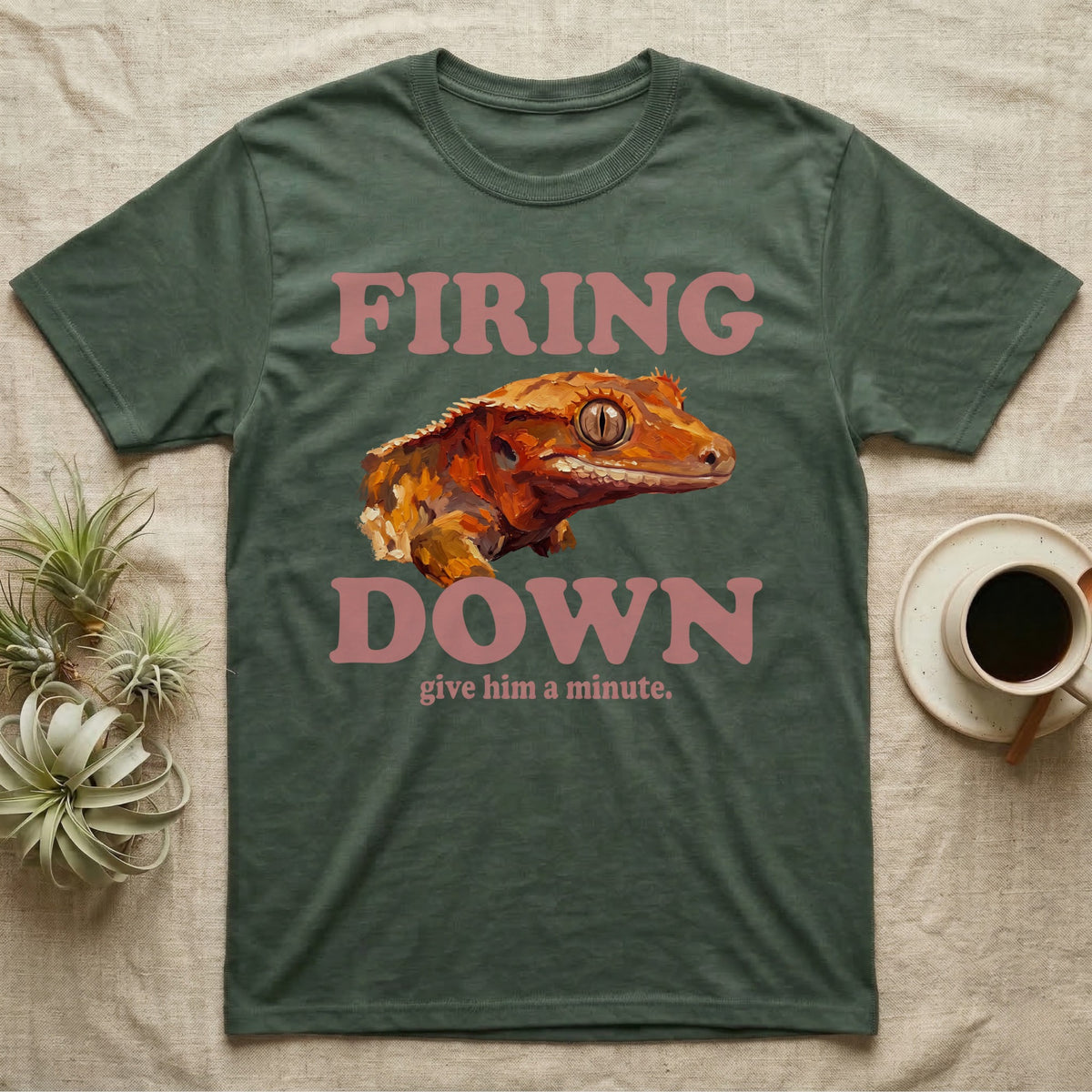Crested Gecko Firing Down T-Shirt in Military Green — Engraved crested gecko in navy ink between the rose words Firing and Down, with give him a minute above.