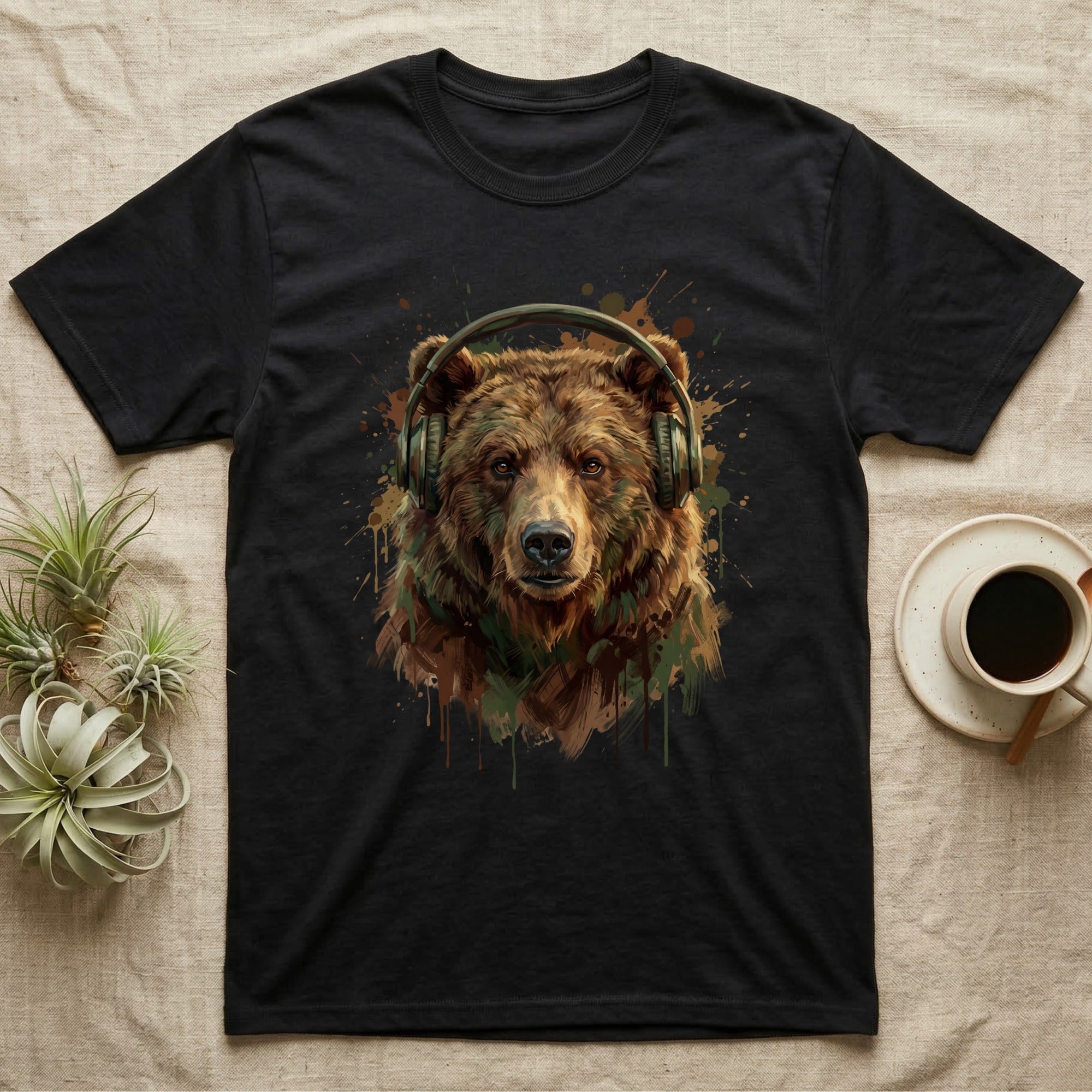 Black t-shirt featuring a painted brown bear wearing headphones and colorful paint splatters.