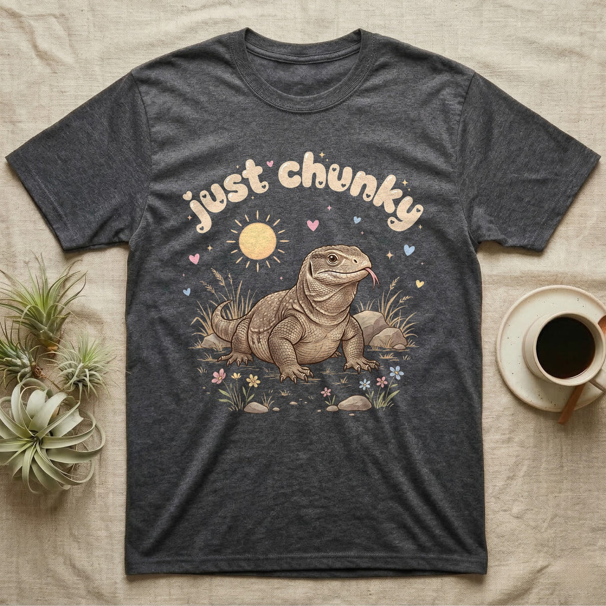 Savannah Monitor Softie T-Shirt in Dark Heather — Plump savannah monitor lizard with flicking tongue under pastel bubble text "just chunky" and hearts.