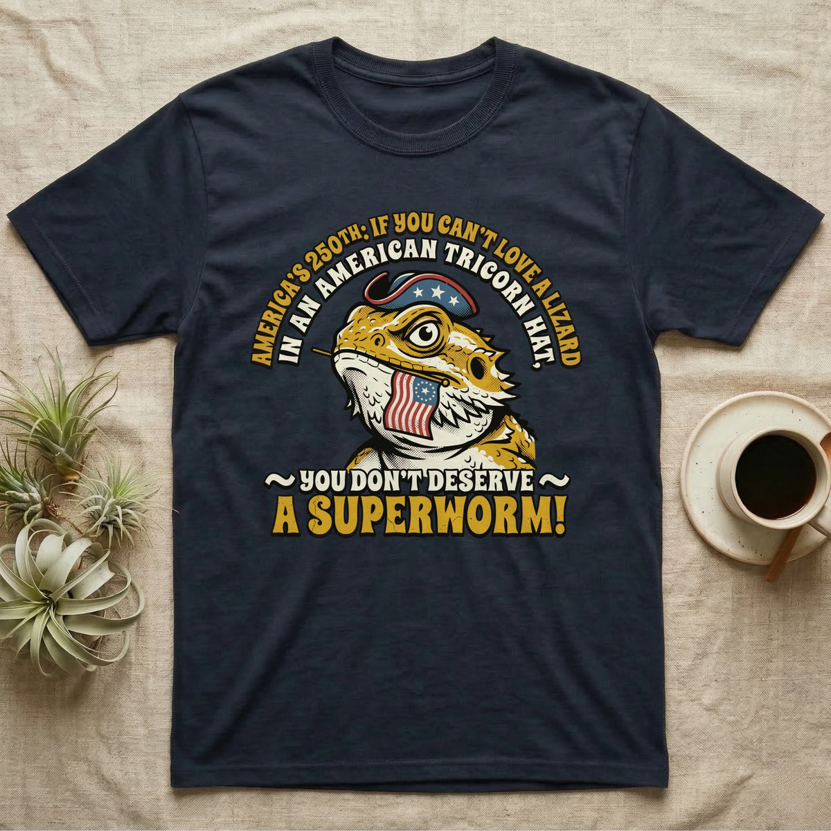 Bearded Dragon Tricorn Tee in Navy — Bold woodcut tee of a bearded dragon in a colonial tricorn hat, gold and cream text reading You Don't Deserve A Superworm, on black.