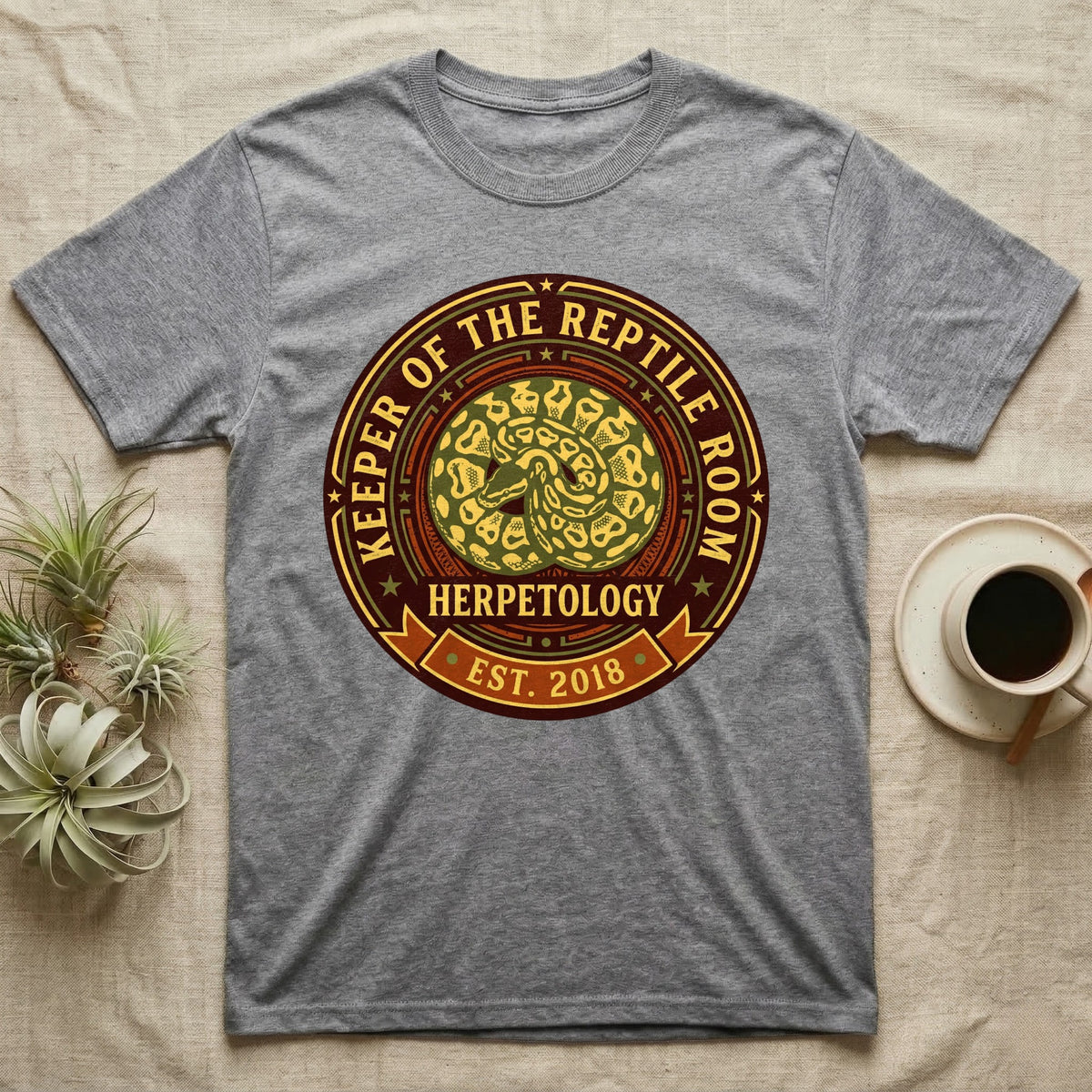 Grey t-shirt with a circular graphic for "Keeper of the Reptile Room Herpetology Est. 2018".