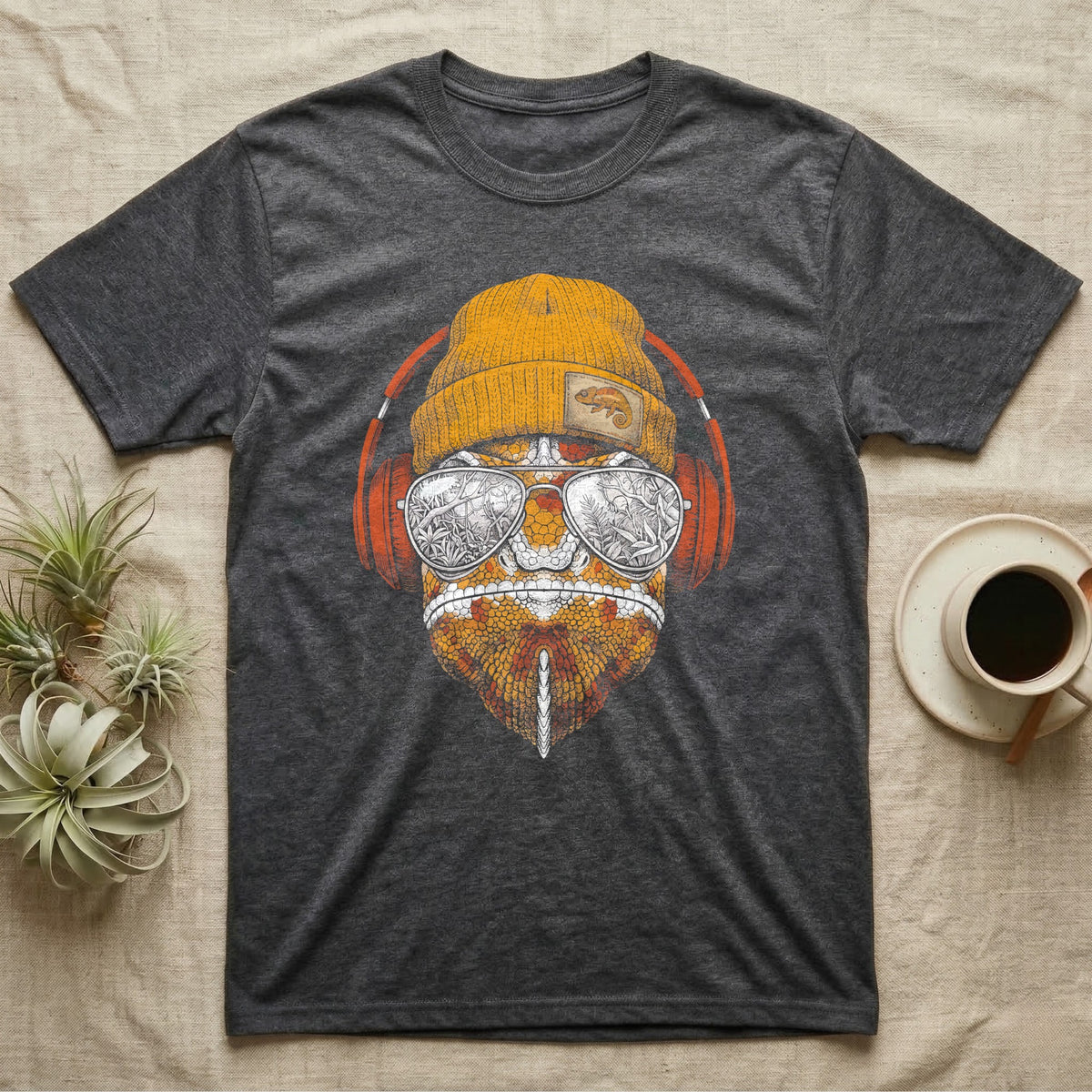 Chameleon Chill Vibes T-Shirt in Dark Heather — Engraved chameleon with patterned orange skin in a beanie and headphones, aviators reflecting a jungle canopy.