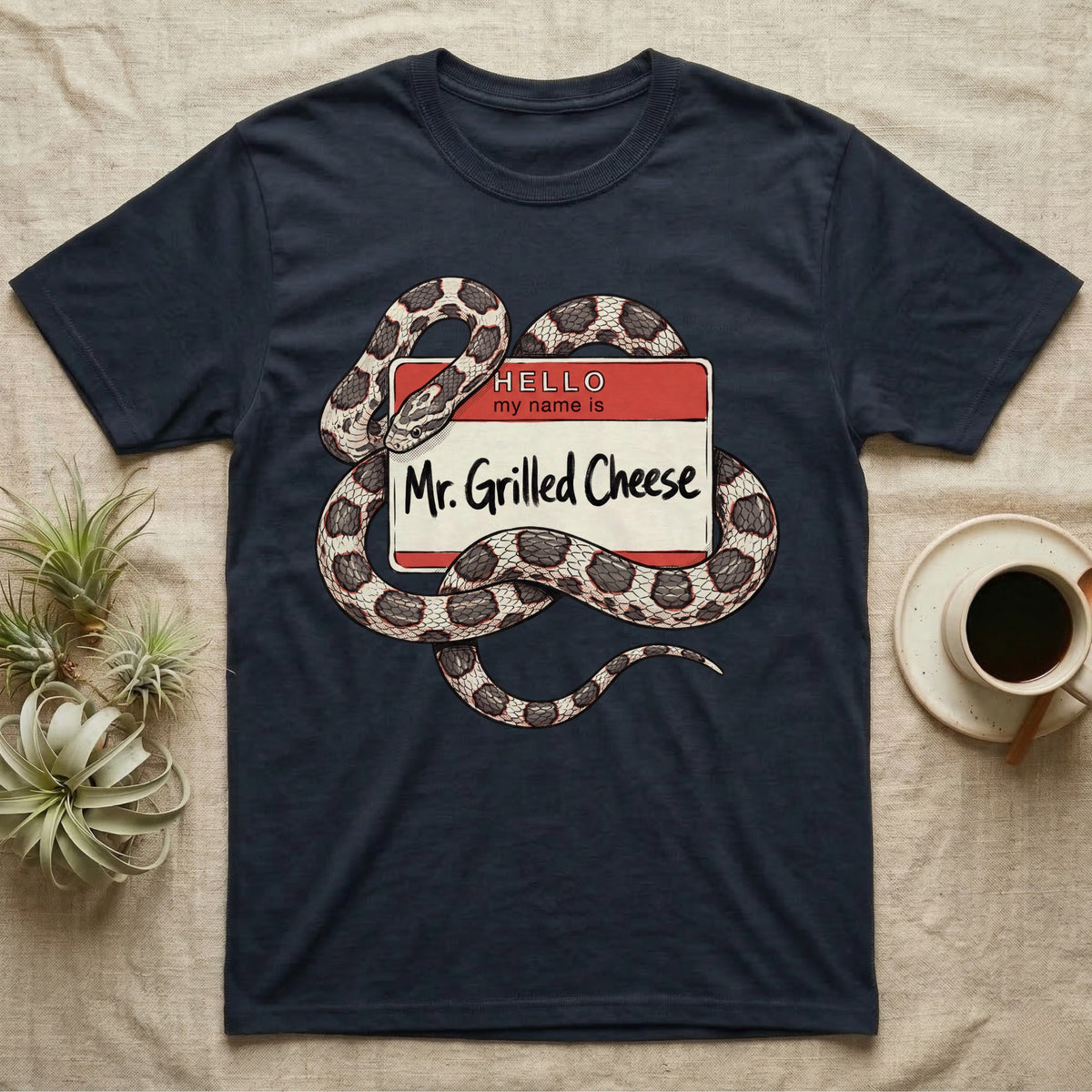 Grilled Cheese Corn Snake T-Shirt in Navy — Flat retro illustration of a corn snake coiled through a "Hello my name is Mr. Grilled Cheese" name-tag badge.