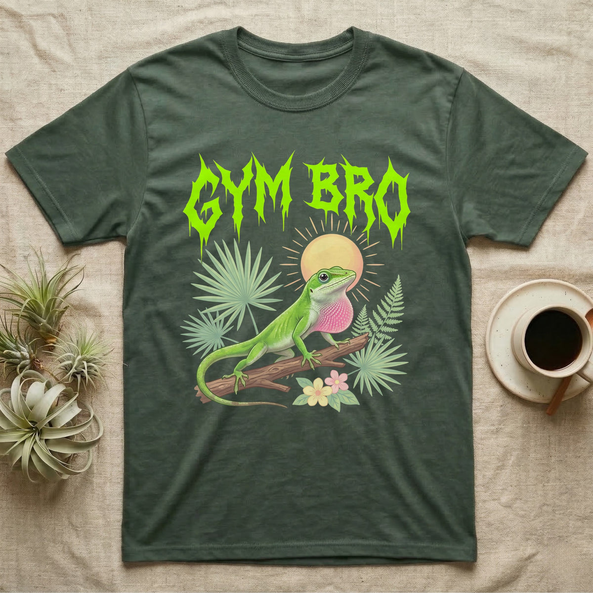 Green Anole Feral T-Shirt in Military Green — Green anole mid push-up with flared pink dewlap under a jagged neon-lime metal "GYM BRO" wordmark and pastel ferns.