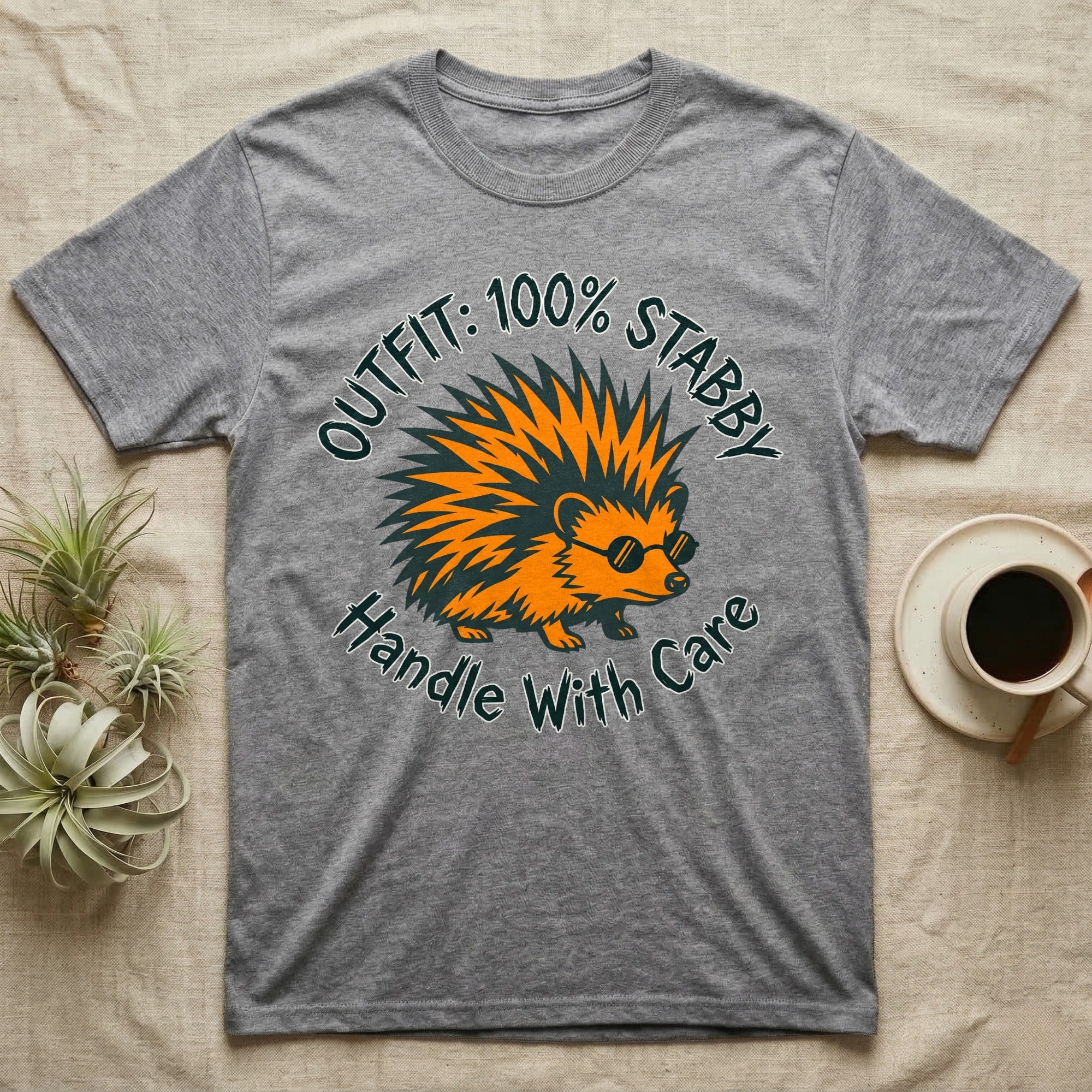 Grey t-shirt with orange spiky hedgehog wearing sunglasses and text "OUTFIT: 100% STABBY HANDLE WITH CARE".
