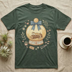 Gecko in a snow globe with flowers and "home is here" tag on a green t-shirt.