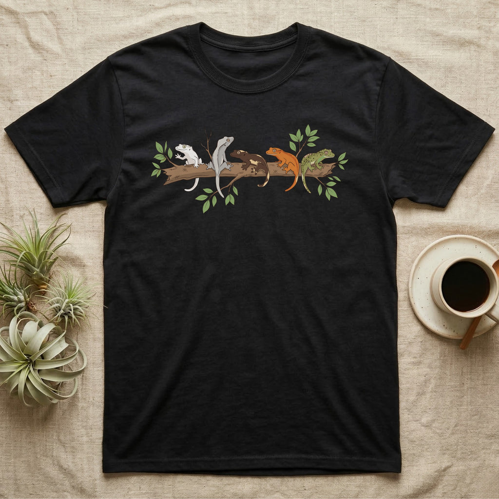 Crested Gecko Morph Line T-Shirt in Black — Five crested gecko morphs in ink and watercolour perched along one cork bark branch with ficus leaves.