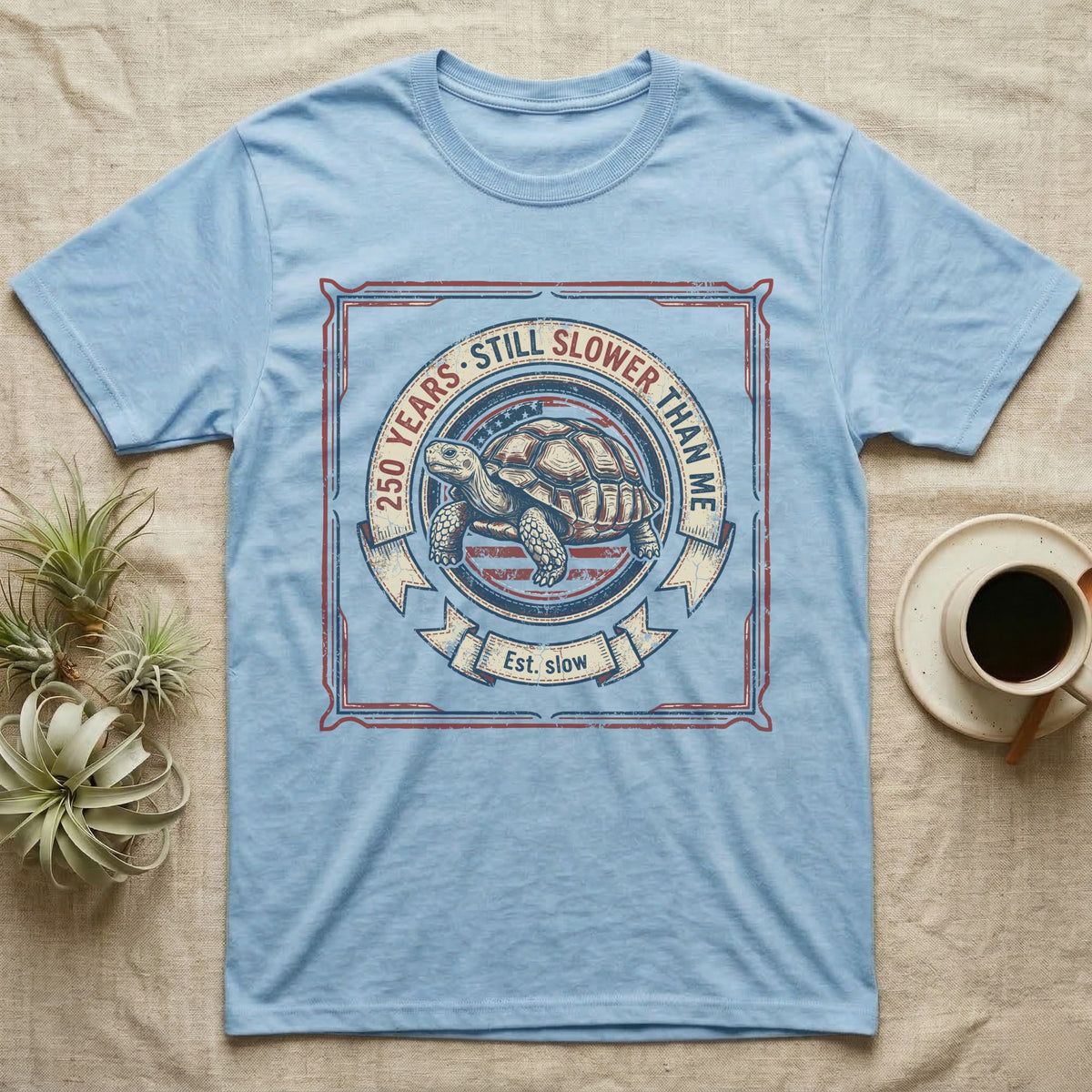 Slower Than Me Tortoise T-Shirt in Light Blue — Vintage-Americana roundel illustration of a tortoise with a banner reading "250 Years, Still Slower Than Me."