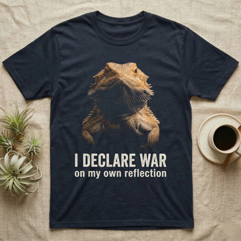 Photographic mugshot of a bearded dragon with beard flared dark above the hook I Declare War, on my own reflection. — shown on a Navy tee.