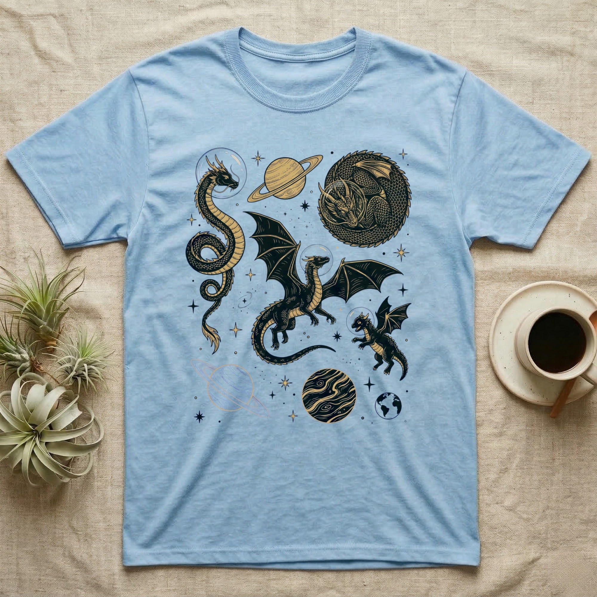 Light blue t-shirt with celestial dragons and planets graphic.